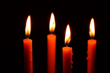 four candles on black background