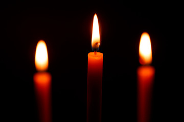 Three candles on black background
