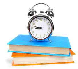 Alarm clock and multi-coloured books.