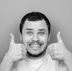 Portrait of with funny expression holding thumbs up - Monocrome