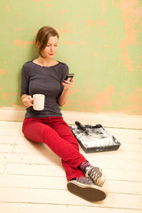 woman reading text message and enjoying a tea break