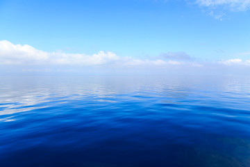 Fototapeta na wymiar Blue ocean water with clouds in the background