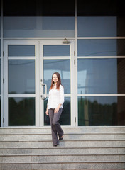 Young business woman descends the stairs to the street