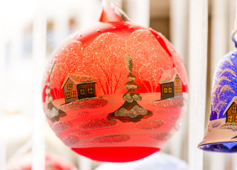 Winter scene painted on a red Christmas ornament