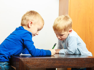 boys children with pen writing doing homework. At home.