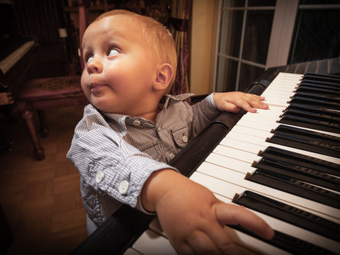 Boy child kid playing on digital keyboard piano synthesizer