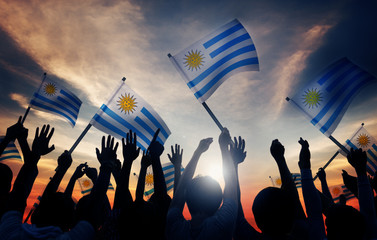 Silhouettes of People Holding Flag of Uruguay - obrazy, fototapety, plakaty