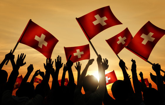 Silhouettes of People Holding Flag of Switzerland