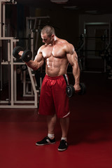 Fototapeta na wymiar Muscular Man Doing Heavy Weight Exercise For Biceps