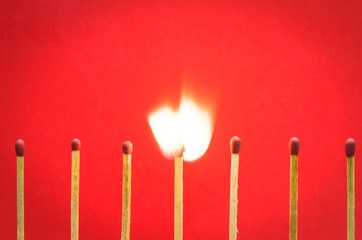 burned match setting on red background for ideas and inspiration