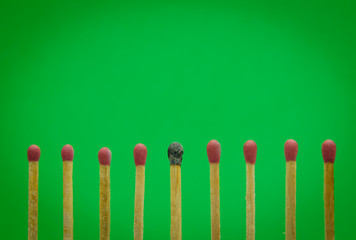burned match setting on green background for ideas and inspirati
