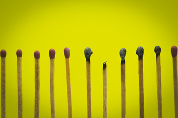 burned match setting on yellow background for ideas and inspirat