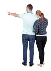young couple pointing at wal Back view