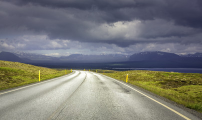 Curved asphalt road in high mountains of Iceland