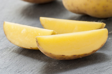 Cut potatoes on black background close up