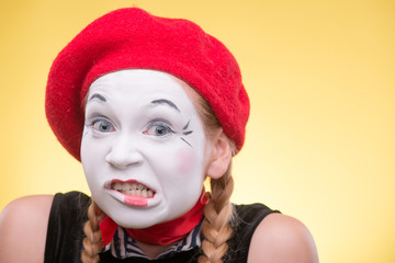 Portrait of female mime isolated on yellow background