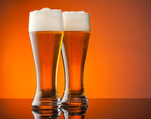 Glasses of beer with orange background
