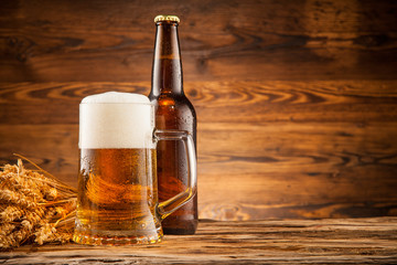 Glass and bottle of beer on wooden planks