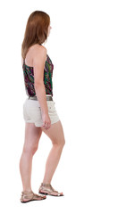 back view of walking  woman in shorts. beautiful blonde girl in