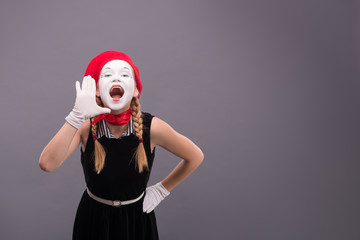 Portrait of female mime in red head and with white face isolated