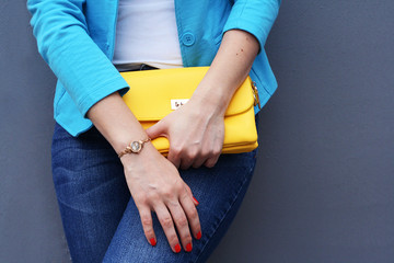 The fashionable young woman  holding yellow clutch