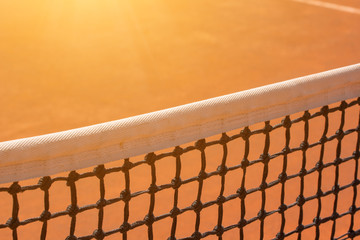 Tennis net on a clay court.