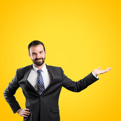 Businessman making showing over yellow background
