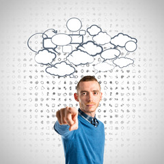 Young man pointing over grey background