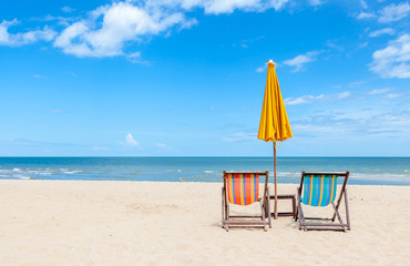Pair of colorful beach chair with sun umbrella on beautiful beac