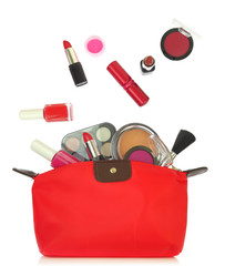 Various cosmetics coming out of a red bag isolated on white