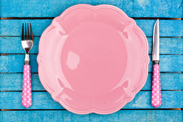 empty plate and fork,knife on a blue wooden background