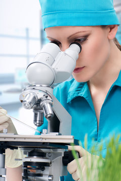 Woman biologist working with microscope