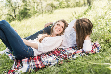 Fototapeta na wymiar girlfriends lying down grass laughing