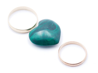 heart of malachite and wedding rings on a white background