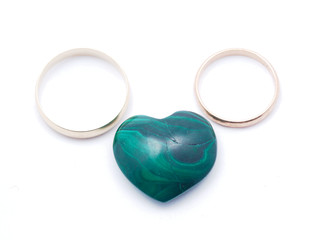 heart of malachite and wedding rings on a white background