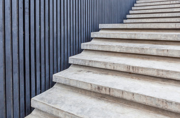 Cement stairway with blue wood wall in modern building.