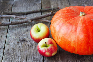 pumpkin and apples on a wooden background
