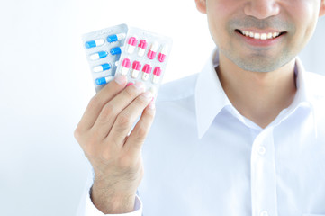 A man holding medicines - blister packs of capsules or pills