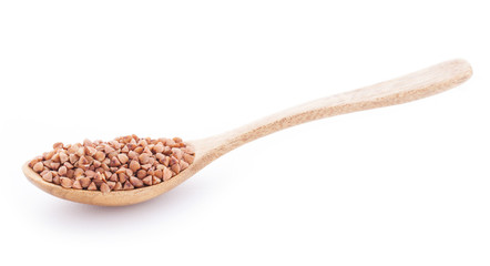 Buckwheat groats in wooden spoon on white background