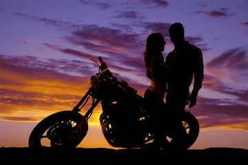 Fototapeta na wymiar silhouette couple look at each other on motorcycle