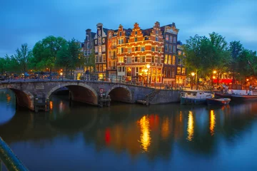 Poster Night city view of Amsterdam canal and bridge © Kavalenkava