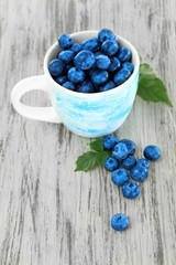 Blueberries in cup on wooden table