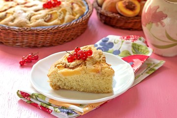 Piece of sweet peach cake with red currants