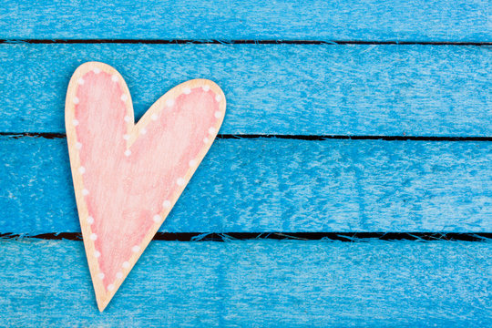 pink wooden heart on a blue background
