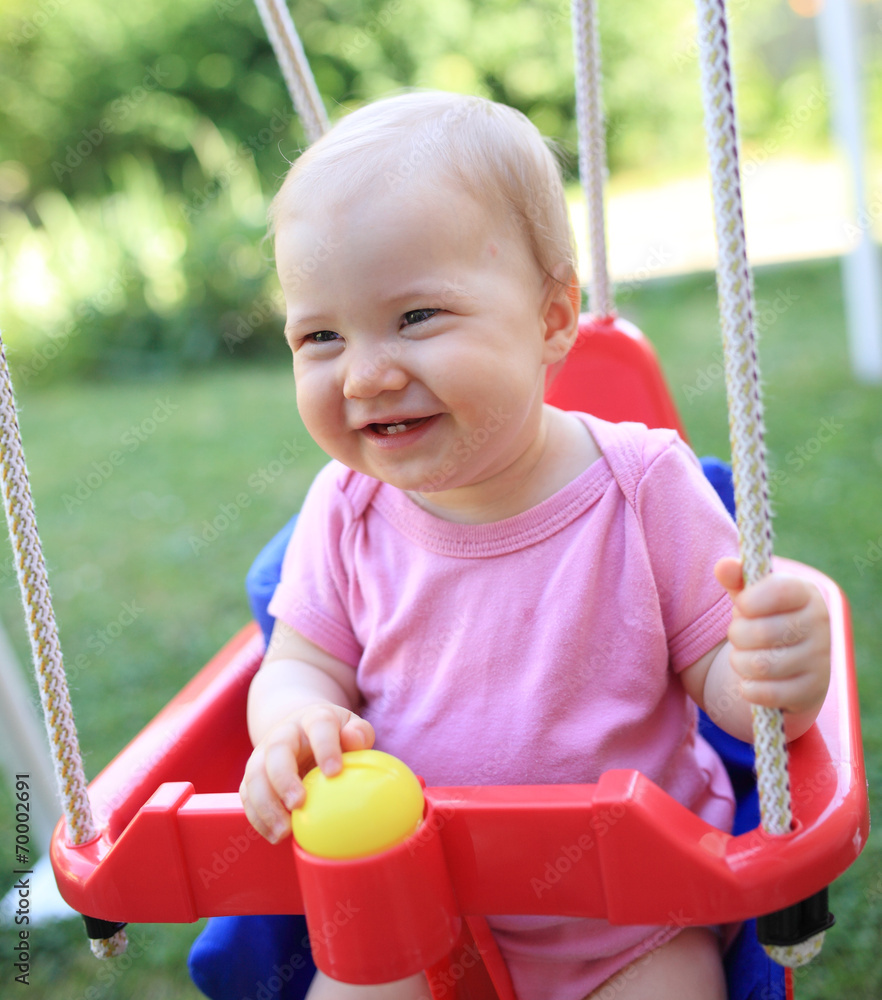 Wall mural young cute child smiling in swing