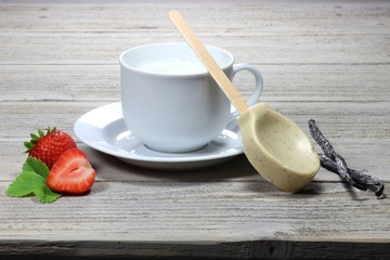 weiße Trinkschokolade mit Erdbeer-Vanille-Geschmack auf Holztisch