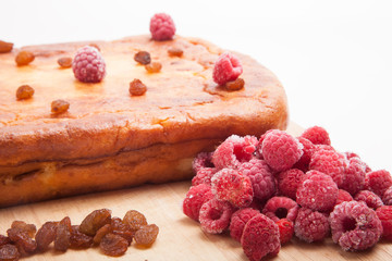 Cottage cheese casserole with raspberries, raisins on a white ba