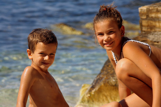 BAMBINI IN SPIAGGIA CON SFONDO D'ACQUA