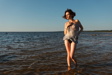 seminude woman against sea background - obrazy, fototapety, plakaty