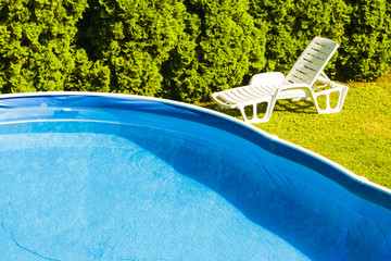 Swimming pool in the garden, lounge chair.